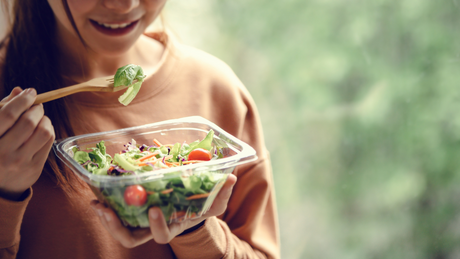 lady holding a plastic salad container