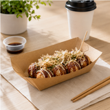 Box of takoyaki with a cup of coffee and soy sauce on a wooden table.